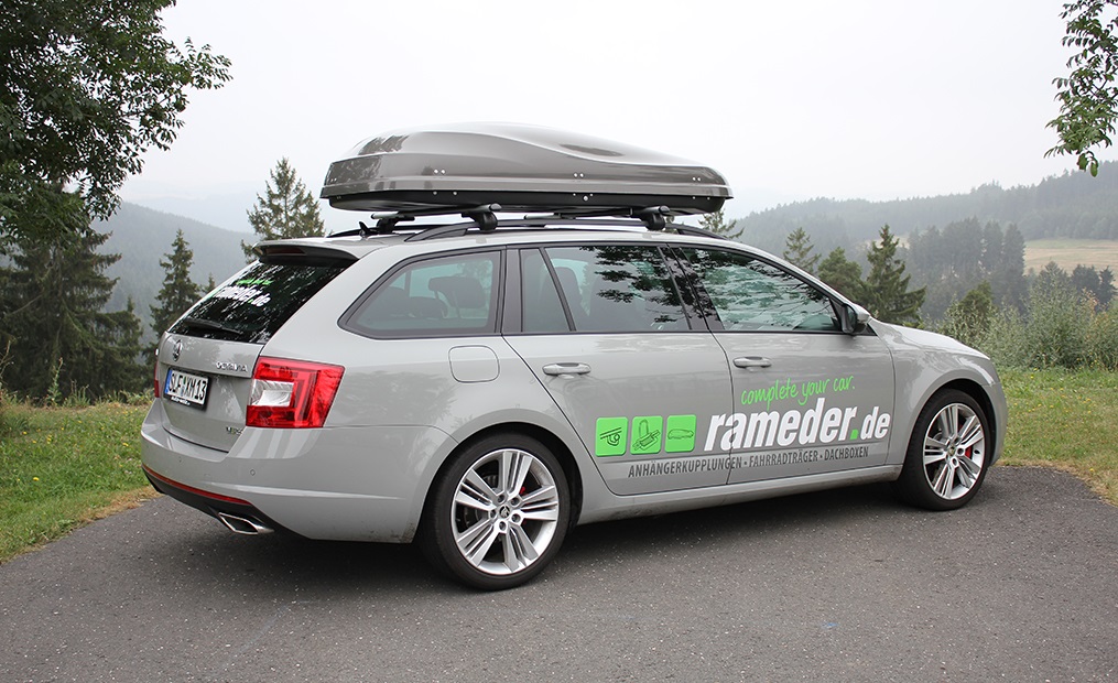 Grauer Kombi mit rameder.de-Schriftzug und grauer Dachbox