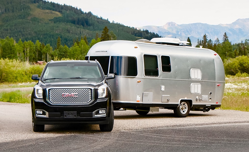 Maximale Anhängelast: Ein schwarzer GMC mit angekuppeltem, grauem Airstream in der Natur