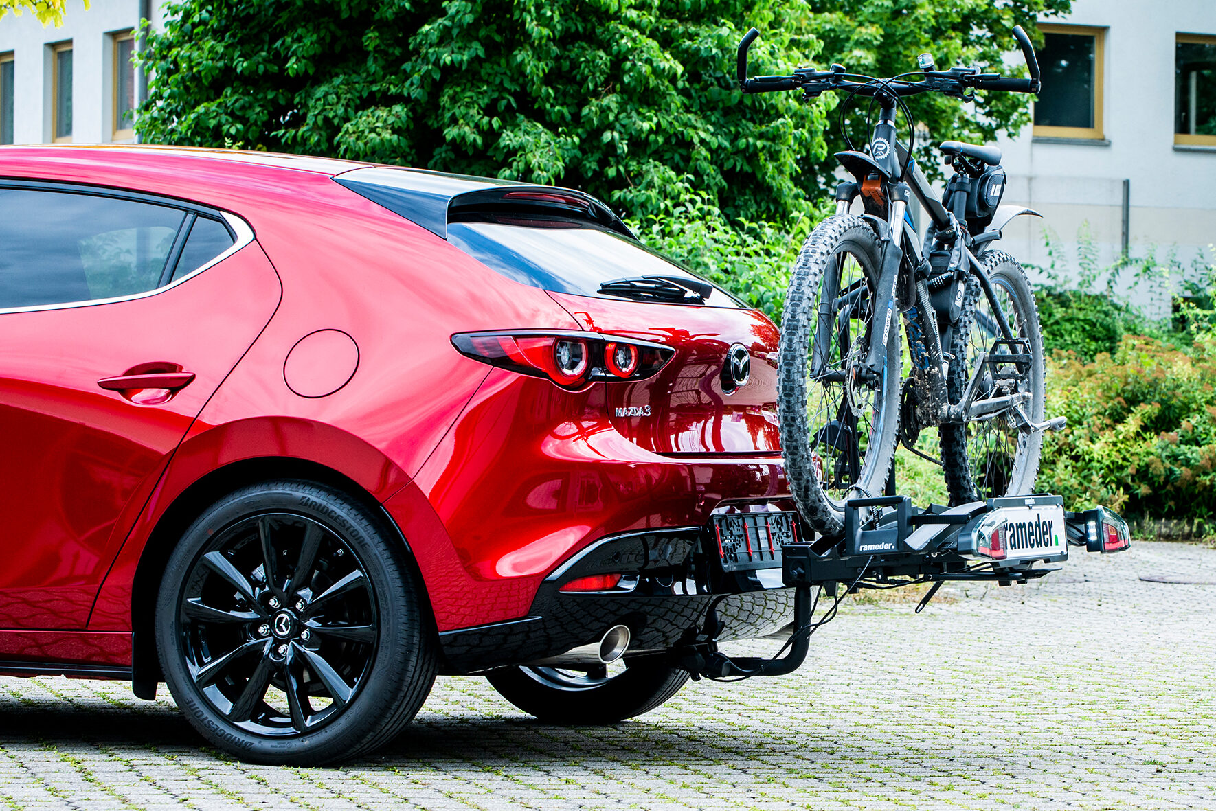 Roter Mazda mit Fahrrad-Heckträger und Mountainbike